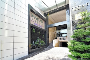 A hotel entrance with a sign for Mayfair Suites and WMC Tower. - Mayfair Suites (Ho Chi Minh City)