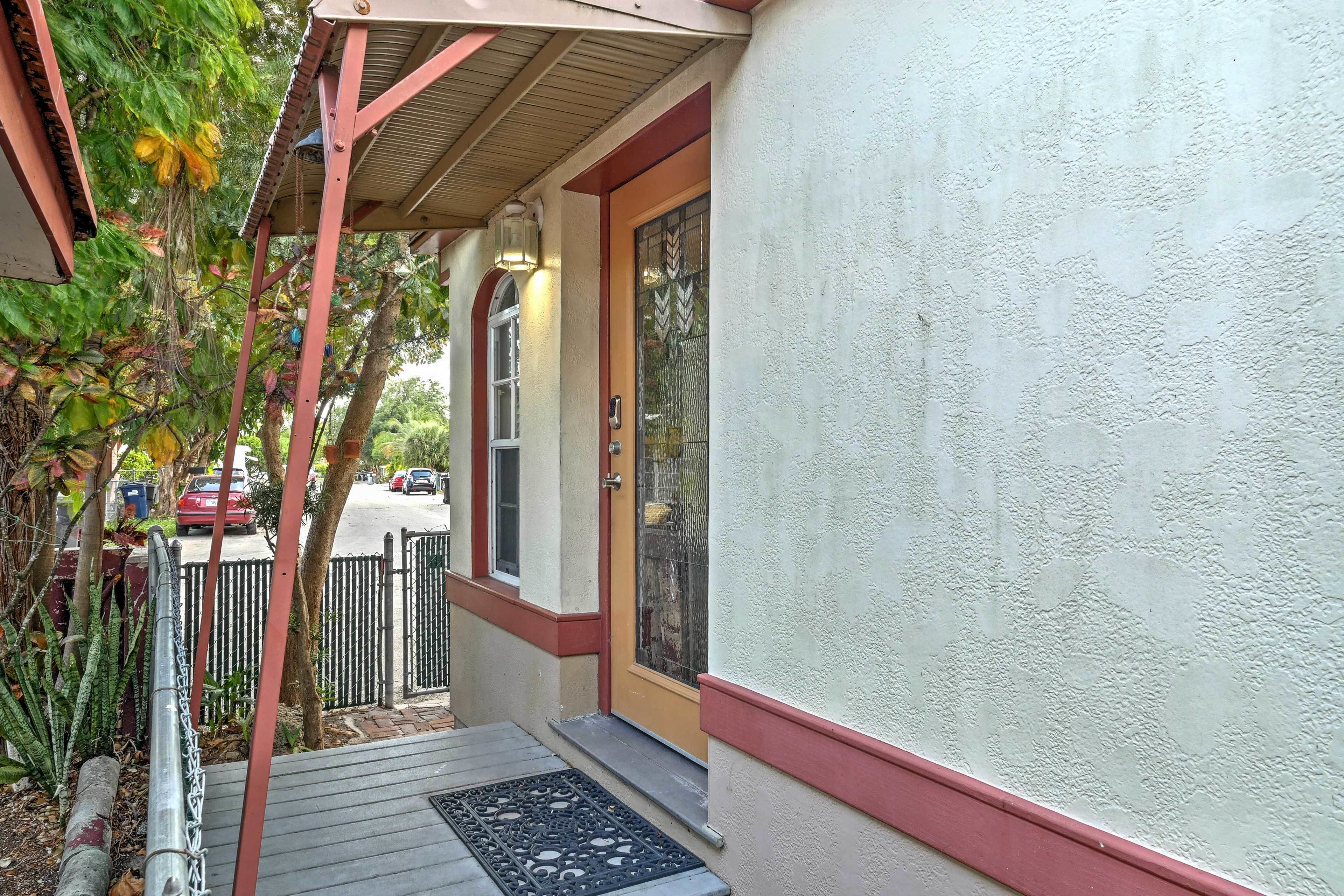 A house with a covered porch, a gated entrance, and a door with a decorative glass panel.