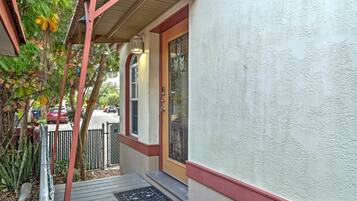 A house with a covered porch, a gated entrance, and a door with a decorative glass panel.