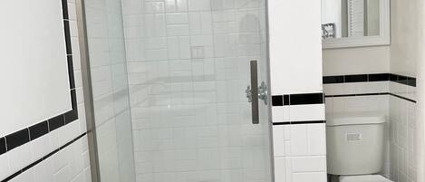 Ein Badezimmer mit Dusche, Toilette und Waschbecken.