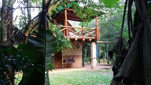 A wooden structure with a covered patio area, surrounded by lush greenery. - Lajas del Puerto (San Ignacio)