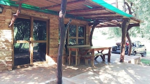 A rustic wooden building with a covered patio area, a bench, and a table. - Lajas del Puerto (San Ignacio)