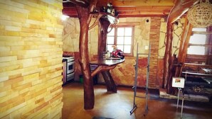 A rustic kitchen with wooden walls, a hanging wooden chair, and a ladder. - Lajas del Puerto (San Ignacio)