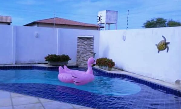 Una piscina al aire libre, una piscina con cascada