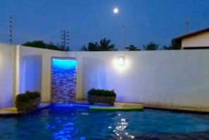 Una piscina al aire libre, una piscina con cascada