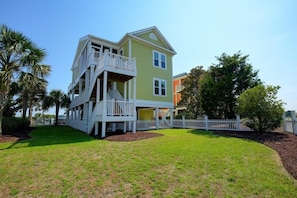 A two-story house with a balcony and a fenced yard. - The Rainbow Connection 4 Bedroom Home by RedAwning (Supply)