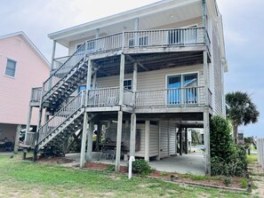 Un immeuble à plusieurs étages doté d’un balcon, d’un escalier et d’un porche couvert.
