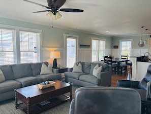 A living room with a sofa, coffee table, and a ceiling fan.