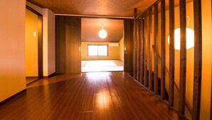 A hallway with wooden flooring, a ceiling fan, and a view of a room with a window. - IMADEGAWA Kyoto (Kyoto)