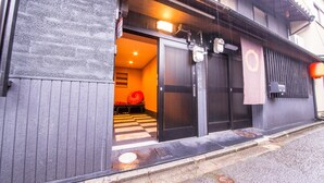 A building with a black exterior, a checkered floor inside, and a red umbrella outside. - IMADEGAWA Kyoto (Kyoto)