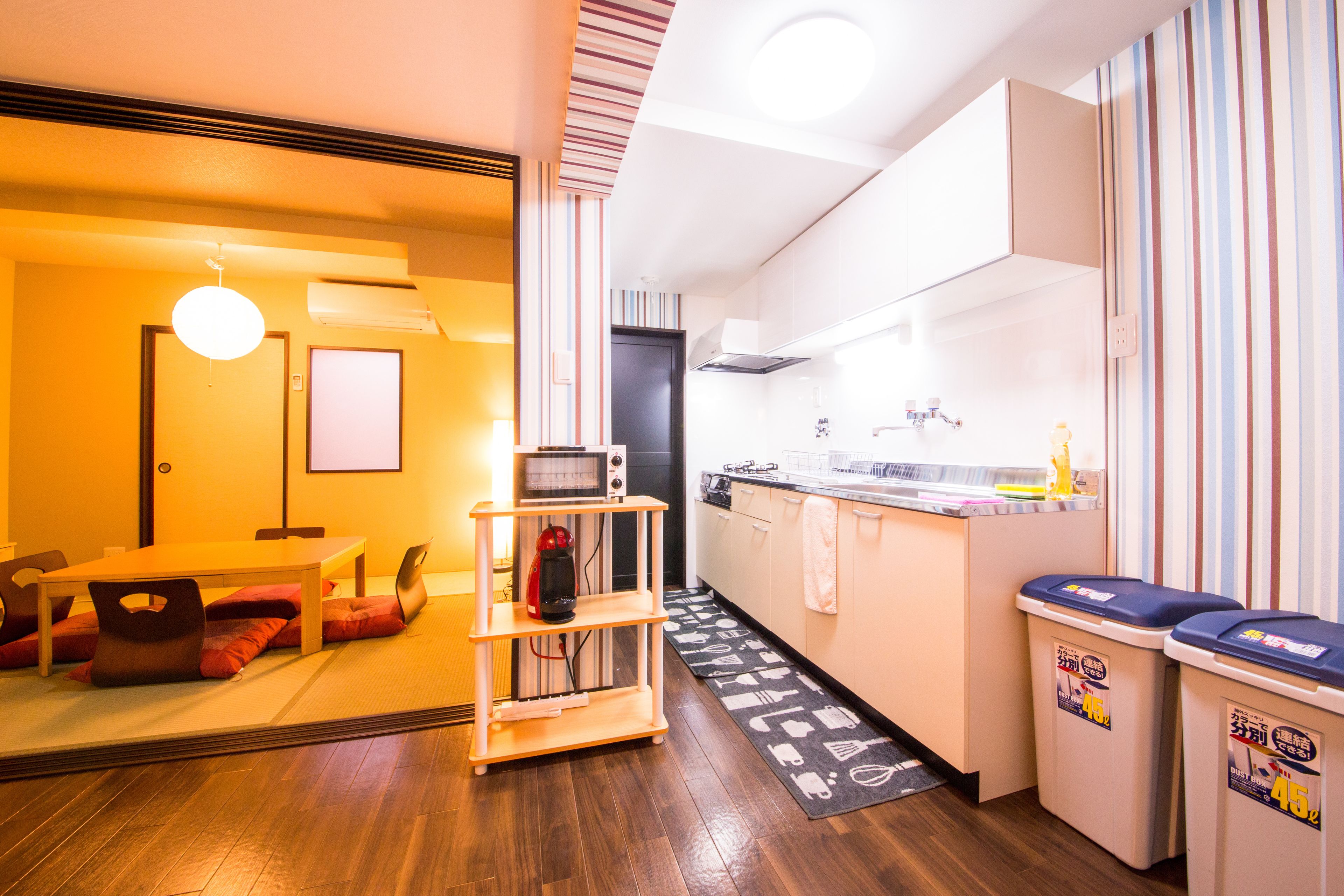 A compact kitchen with a microwave, sink, and a small dining area with a table and chairs.
