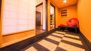 A hallway with a checkered floor, a wooden bench, and a red umbrella. - IMADEGAWA Kyoto (Kyoto)