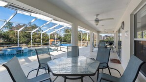 A covered outdoor area with a pool, seating, and a view of the surrounding landscape. - North Timucuan Trail 1208 3 Bedroom Villa by RedAwning (Inverness)