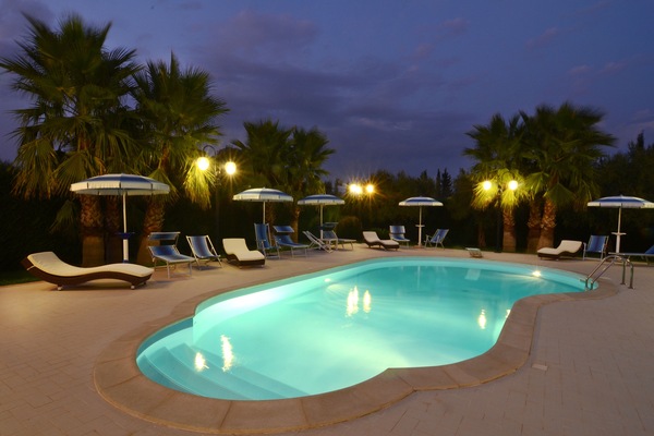 Una piscina al aire libre de temporada, sombrillas
