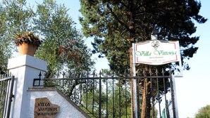 Señal de Villa Vittoria Bed & Breakfast, con una reja de hierro forjado y una placa de piedra.