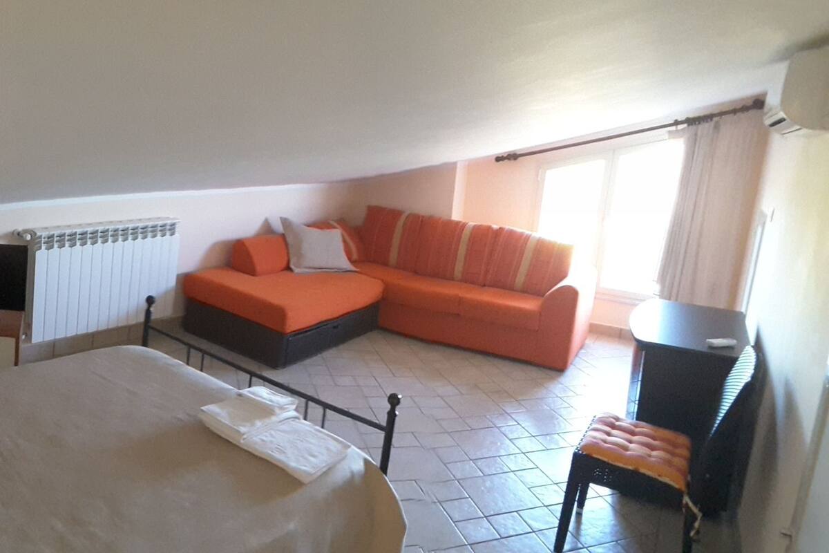 Ein Hotelzimmer mit einem Bett, einem Fernseher, einer Couch und einem Schreibtisch.