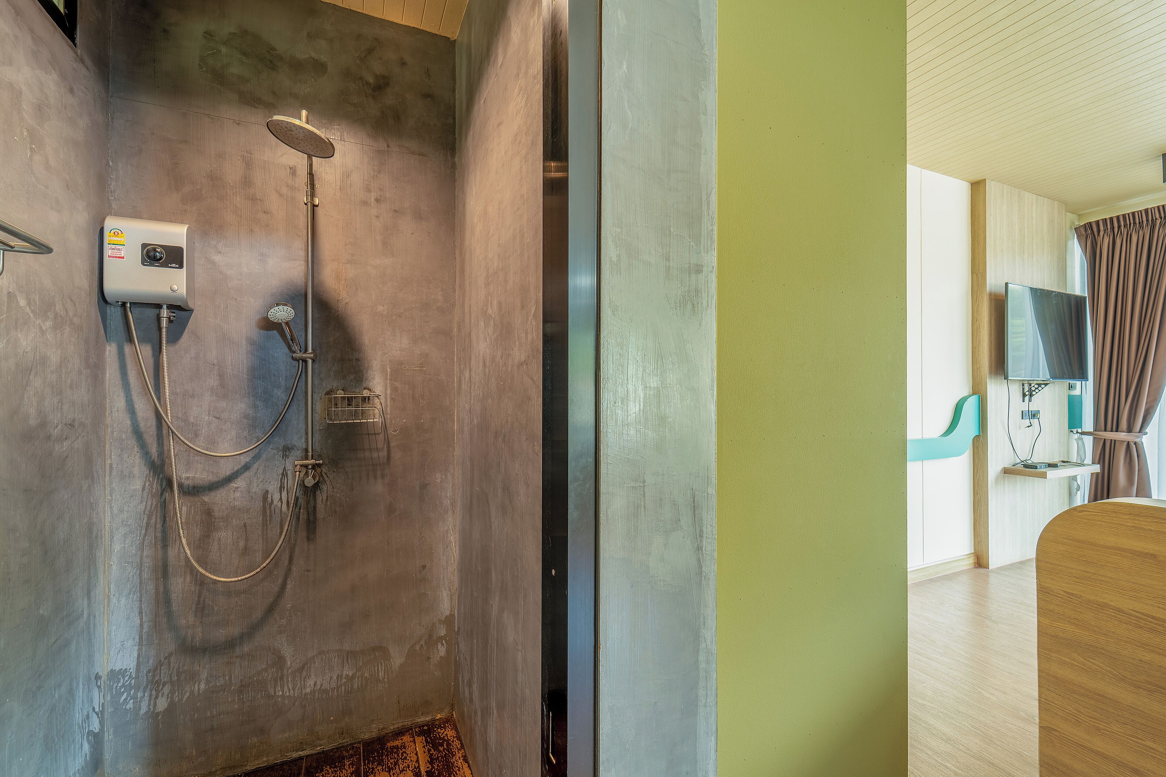 A modern bathroom with a shower, a built-in TV, and a wooden vanity.