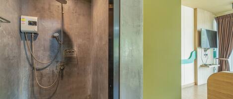 A modern bathroom with a shower, a built-in TV, and a wooden vanity.