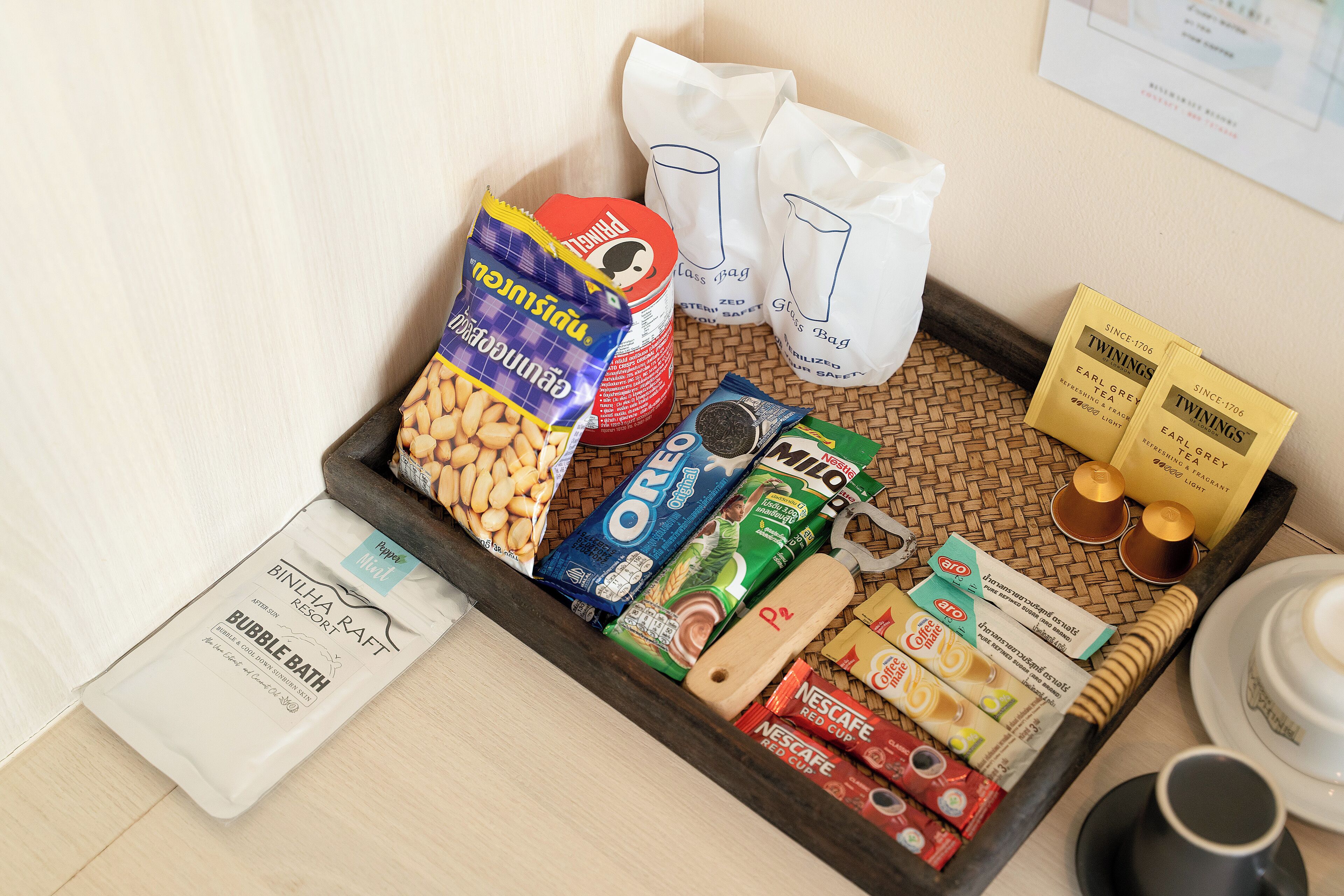 A tray with various food items, including nuts, cereal, and coffee products, on a wooden table.