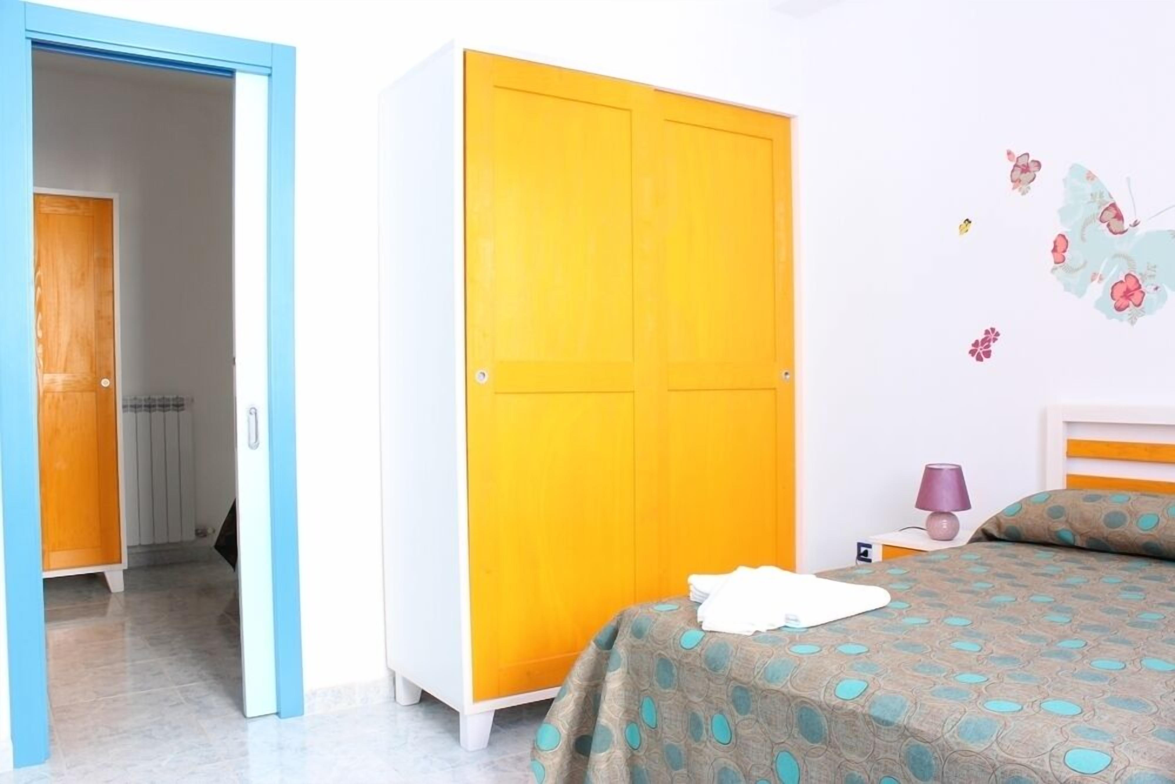 A bedroom with a bed, a wardrobe, and a nightstand.