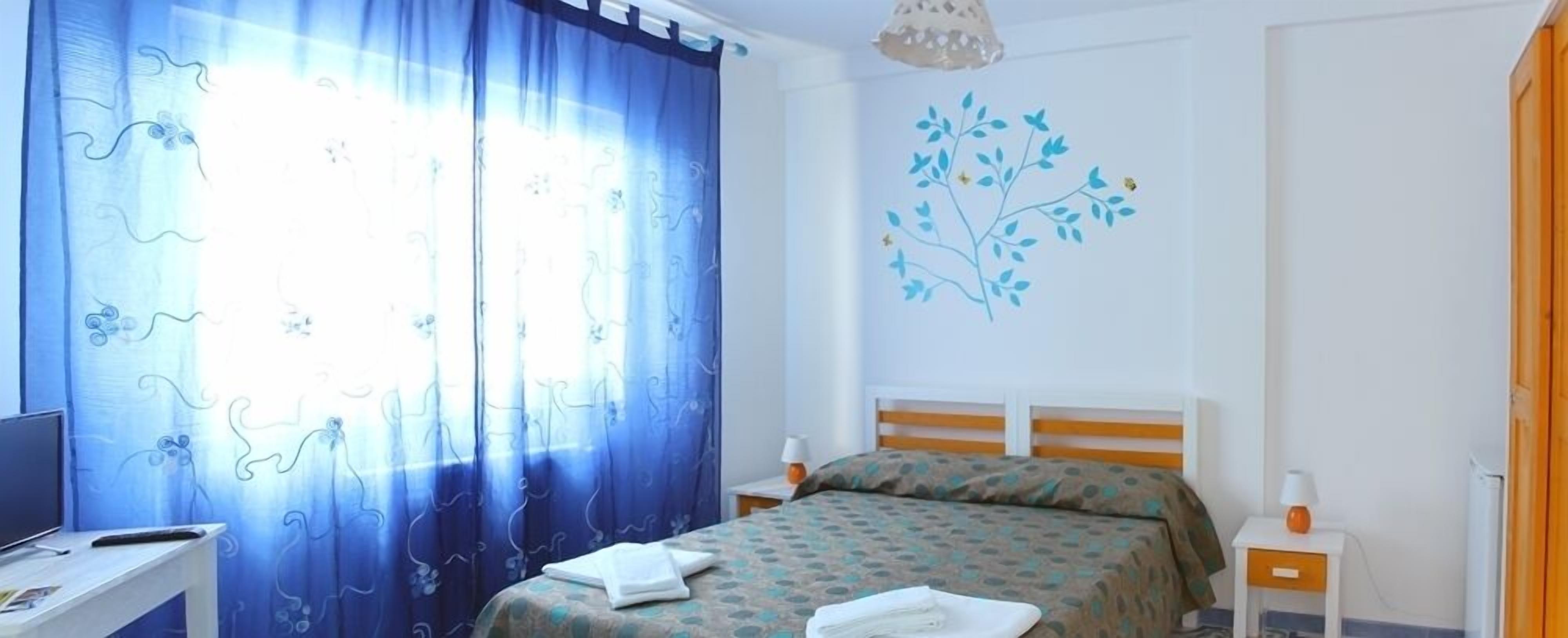 Una camera da letto con un letto, una scrivania e una sedia.