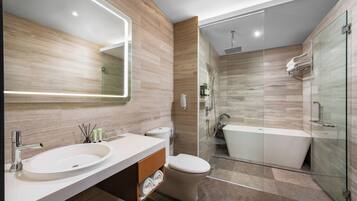 Un baño moderno con un espejo grande, un lavamanos, un inodoro, una ducha con mampara de vidrio y una bañera.