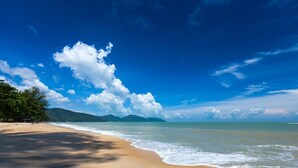 Una playa con cielos despejados y aguas tranquilas.