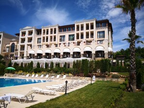Un hôtel doté d’une piscine, de chaises longues et d’un jardin.