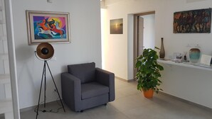 Una sala de estar moderna con un sofá gris, una lámpara de pie y una planta en maceta.