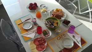 Una mesa de desayuno con diferentes alimentos y utensilios.