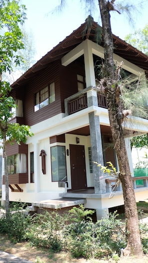 A two-story house with a balcony, a front door, and a small porch.