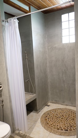 A bathroom with a shower, a toilet, and a sink.