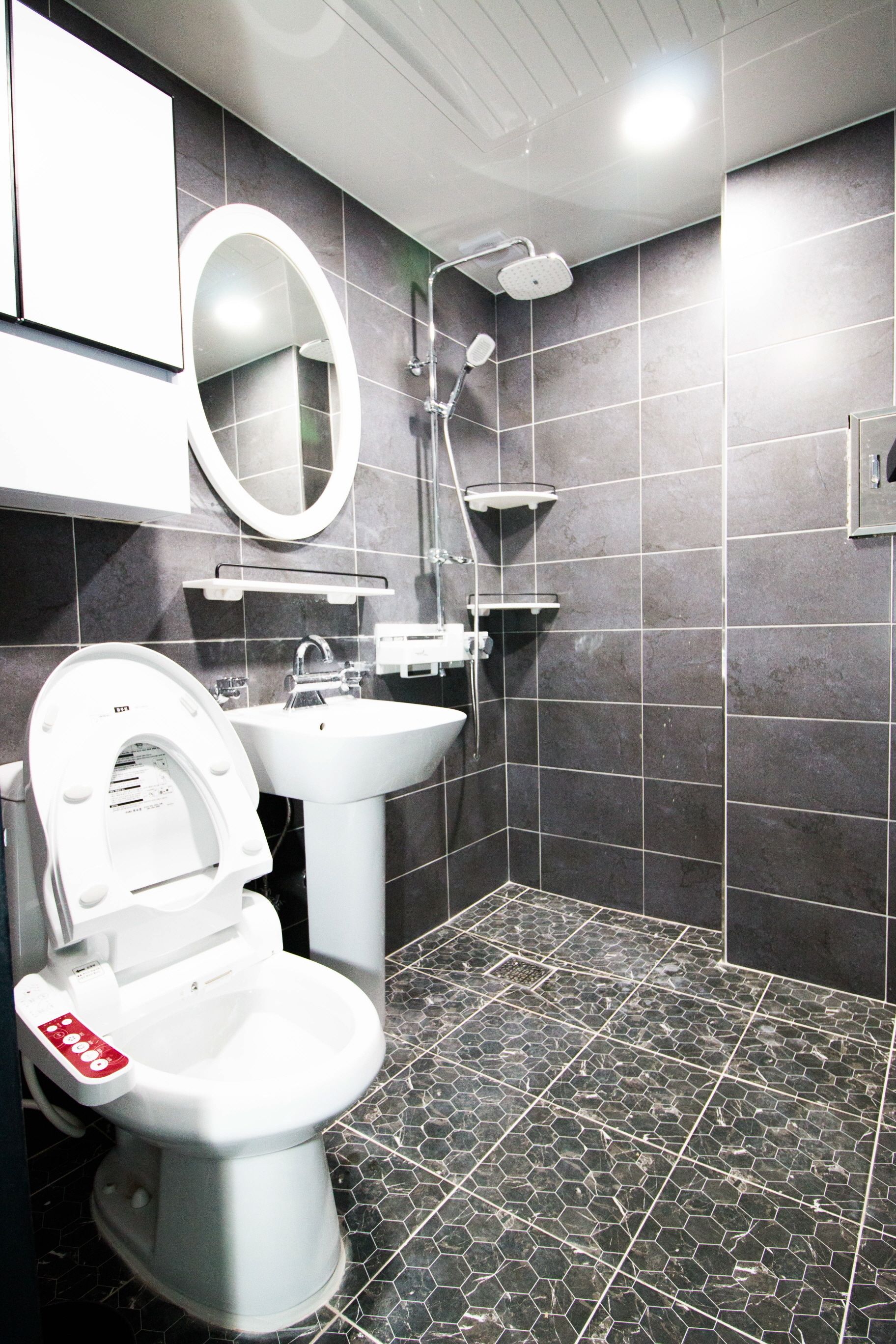 A modern bathroom with a toilet, sink, and shower.