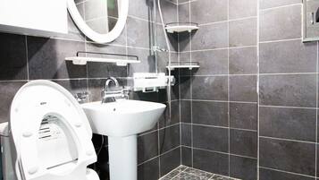 A modern bathroom with a toilet, sink, and shower.