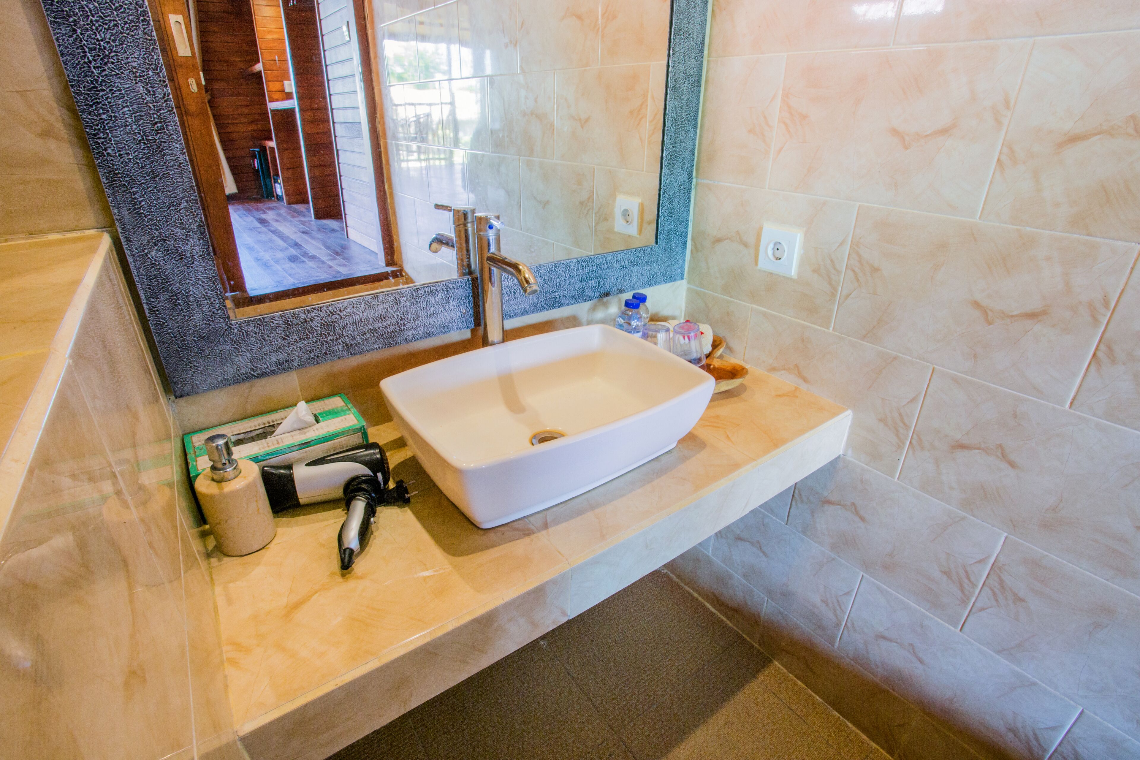 A bathroom with a large white sink, a mirror, and a towel rack.