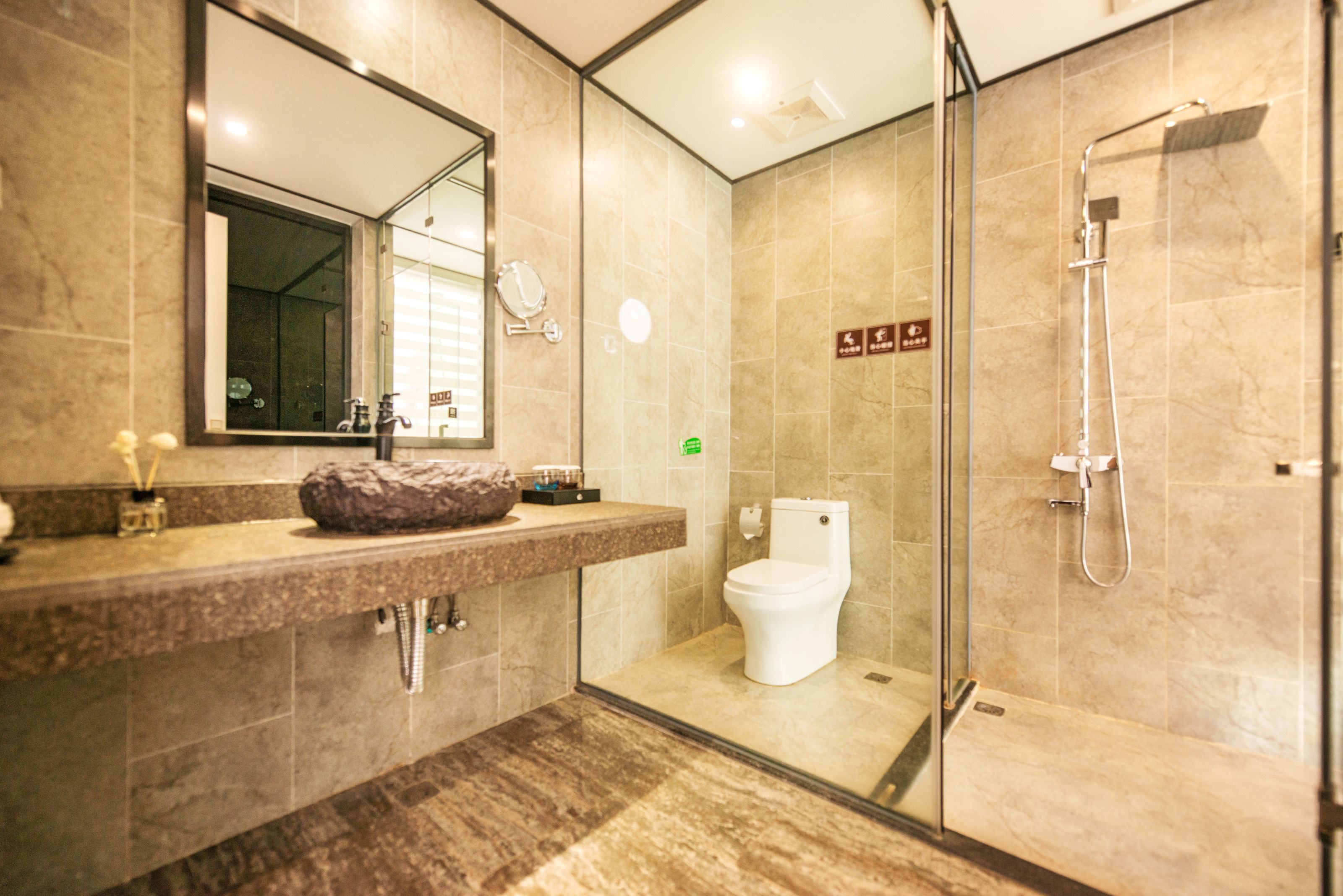 Ein modernes Badezimmer mit Marmorplatte, Duschkabine aus Glas und Toilette.