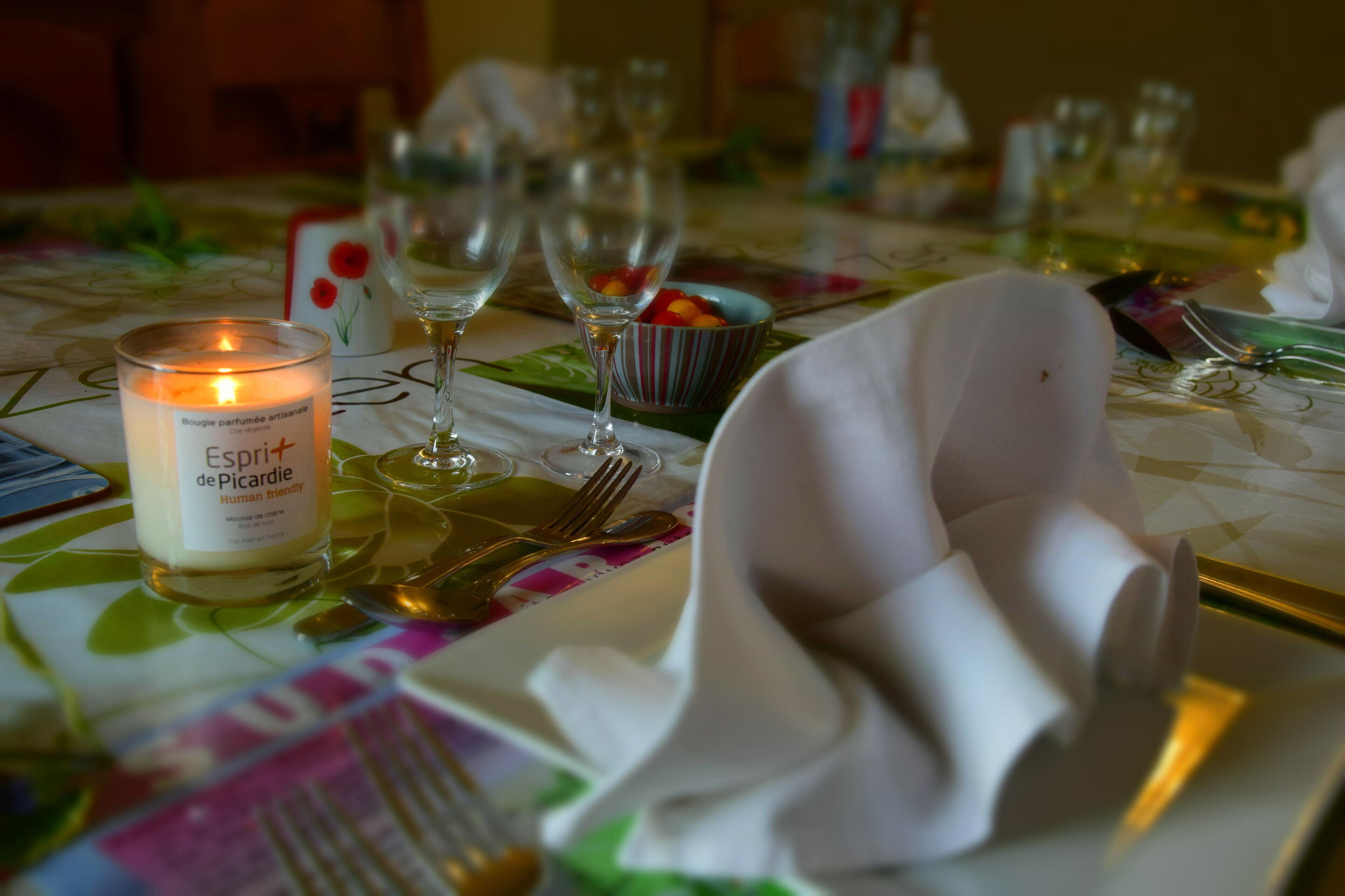 A table set for a meal with a candle, wine glasses, and cutlery.