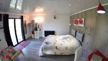 A bedroom with a bed, a desk, a chair, a bookshelf, a fireplace, and a window.