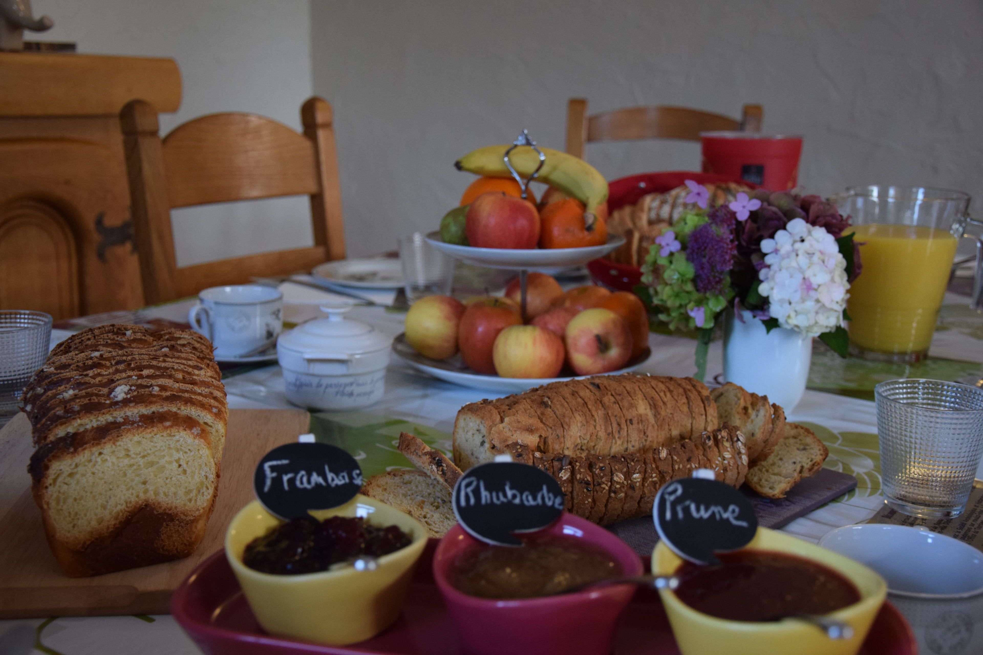 Una tavola imbandita con pane, frutta e condimenti.
