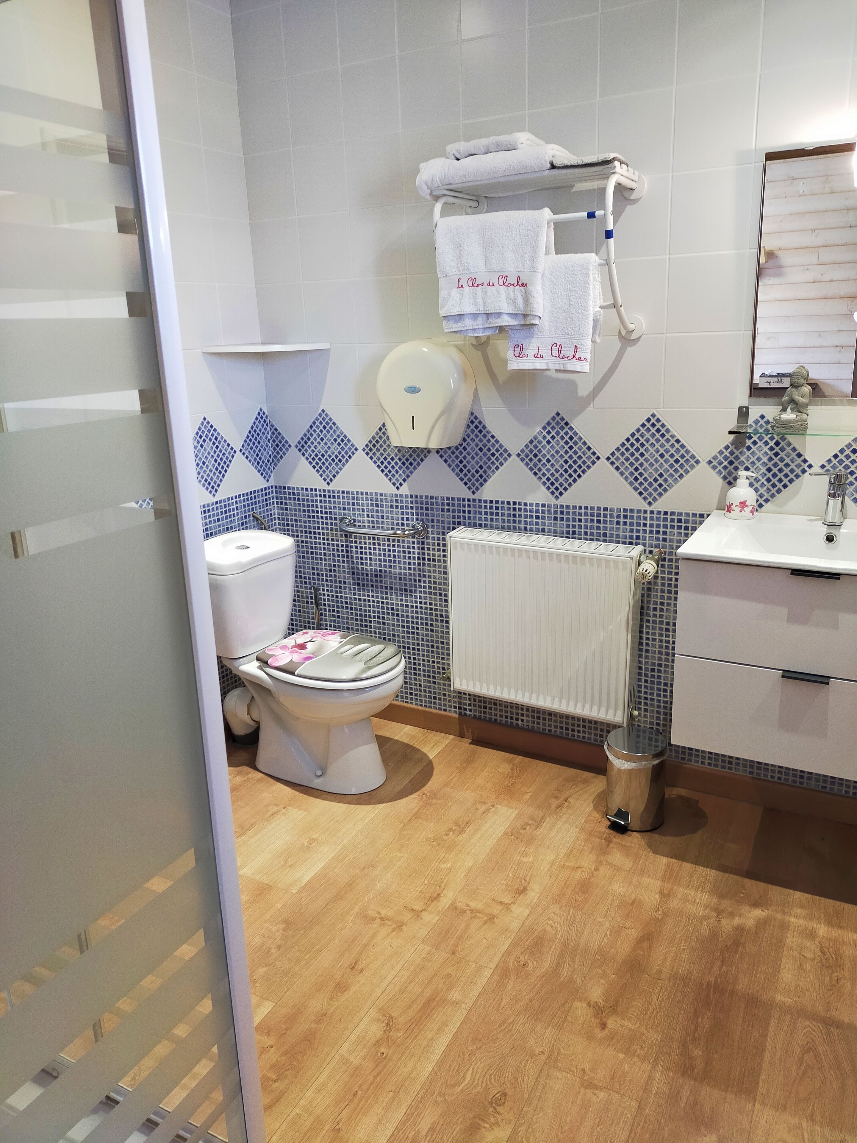 Et badeværelse med toilet, håndtørrer, radiator og vask.