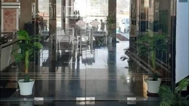 A modern interior with a glass entrance, a sign reading "RESTAURANT", and potted plants. - Hotel Royal Country Club (Pindra)