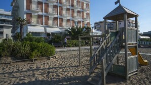 A beachfront hotel with a pool area and a lifeguard station. - Hotel Ariston (Caorle)