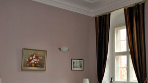 A bedroom with two beds, a chandelier, a window with curtains, and a painting on the wall. - Schloss Triestewitz (Arzberg)