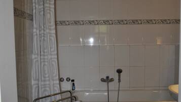 Une salle de bain équipée d’une baignoire, d’une douche et d’un porte-serviettes avec une serviette.