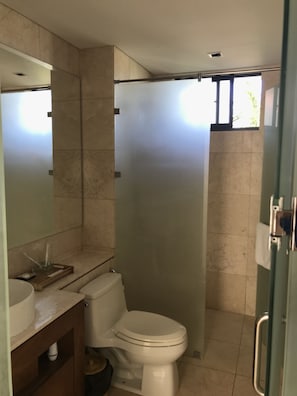 A modern bathroom with a toilet, sink, and shower. - Ocean Resort 3 Bedrooms Danang Living (Da Nang)