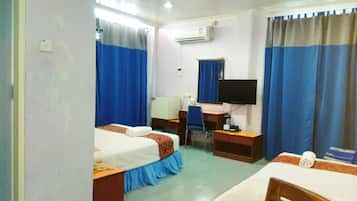 A hotel room with two beds, a desk, a chair, a TV, and an air conditioning unit.