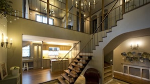 A spacious interior with a grand staircase, a kitchen, and a dining area. - Chambre d'hôte  Étoile et fées (Komatsu)