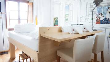A room with a bed, a desk, and a chair.