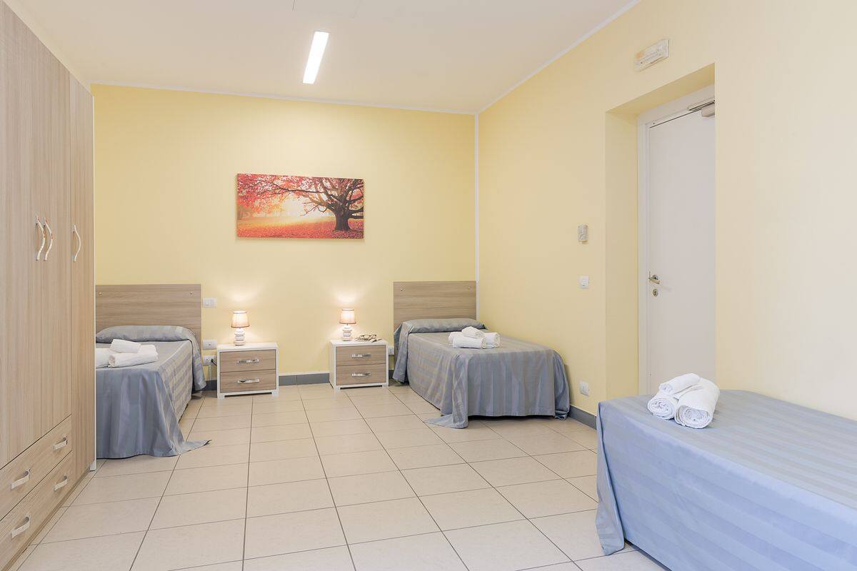 Una habitación de hotel con dos camas, un cuadro en la pared y una puerta.