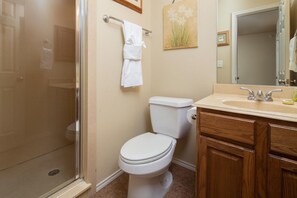 Un baño con inodoro, lavamanos, ducha y toallero.